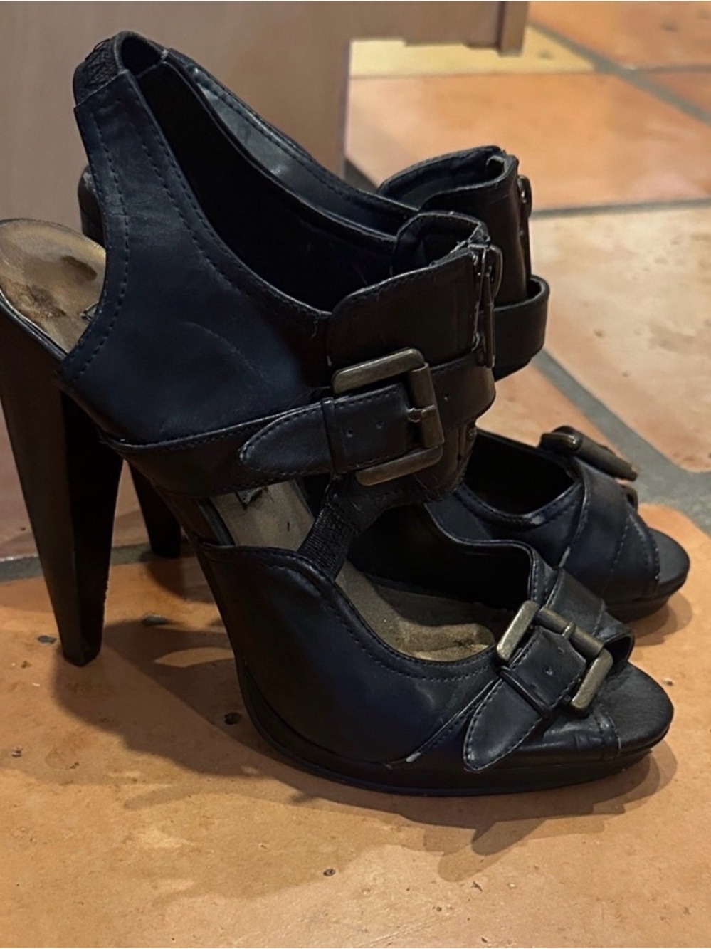 Black heels, very high profile. Buckles and zip detail